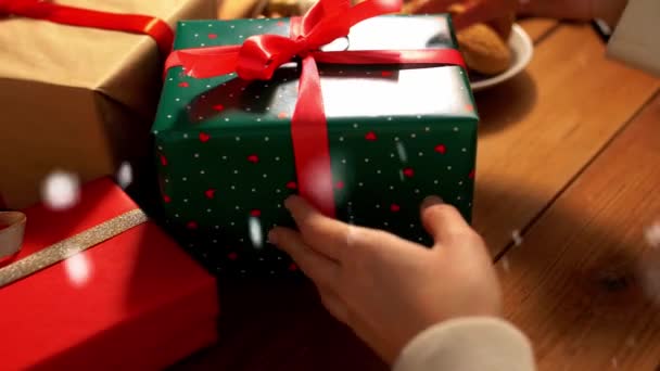 Ręce układania pakowane prezenty świąteczne na stole — Wideo stockowe
