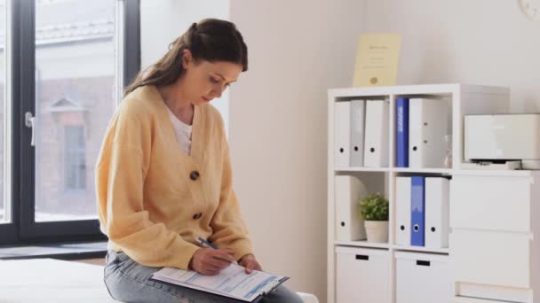 Paziente donna che dà documenti al medico presso la clinica — Video Stock