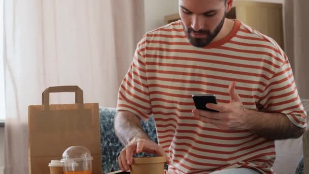 Hombre con teléfono comprobar la orden de comida en casa — Vídeos de Stock