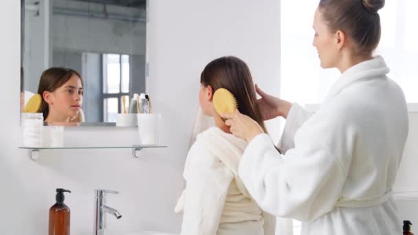 Mother and daughter brushing hair in bathroom — Stock Video © Syda_Productions #572498378