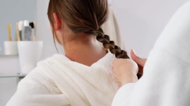 Madre e hija trenzando el cabello en el baño — Vídeos de Stock