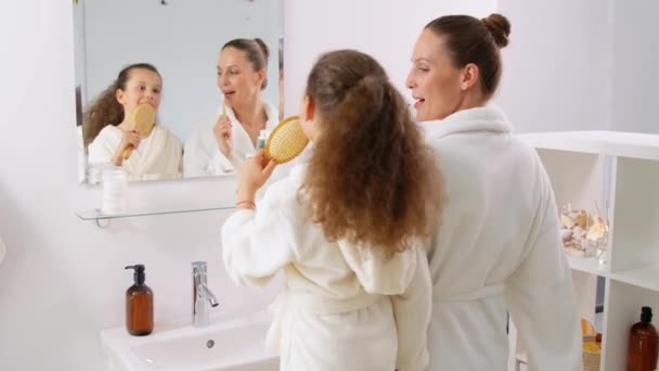 Щаслива мати і дочка співають у ванній — стокове відео