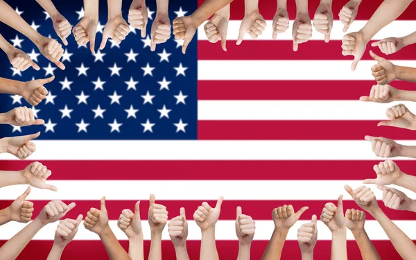 Mãos mostrando polegares para cima sobre a bandeira dos estados unidos — Fotografia de Stock