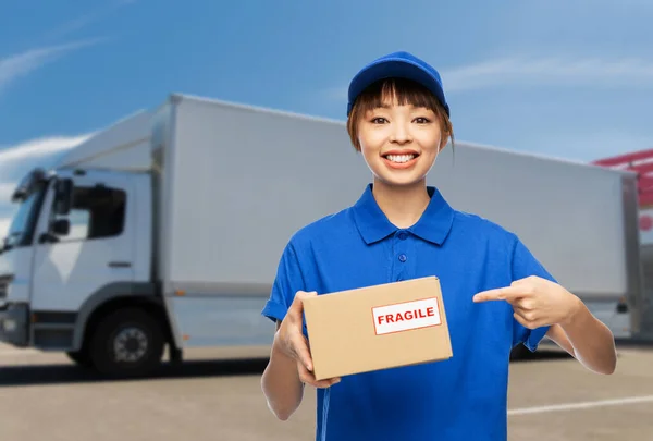 Šťastná dodávka žena drží balíček krabice přes kamion — Stock fotografie