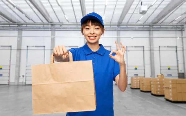 Delivery woman with paper bag showing ok sign — Photo