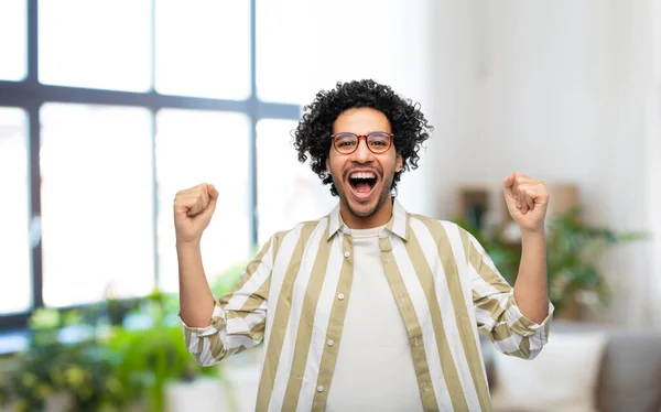 Hombre feliz en gafas celebrando la victoria en casa —  Fotos de Stock