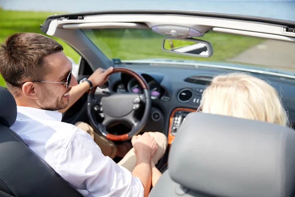 Feliz pareja conduciendo en coche descapotable — Foto de Stock