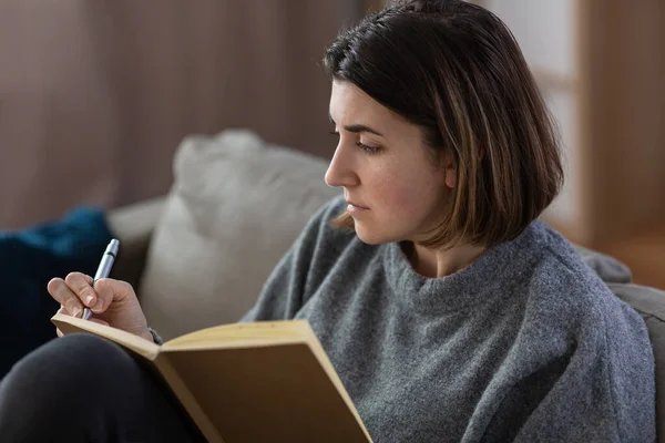 Llorando mujer con diario sentado en el sofá en casa — Foto de Stock