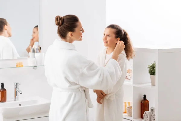 Glückliche Mutter putzt Töchtern Ohr im Badezimmer — Stockfoto