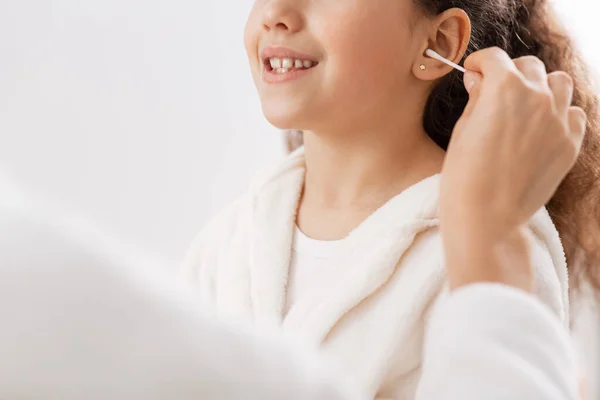 Happy mother cleaning daughters ear in bathroom — Stock Photo, Image