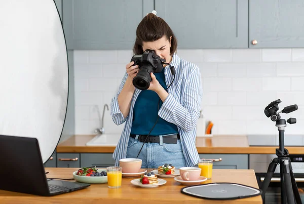 Харчовий фотограф з камерою, що працює на кухні — стокове фото