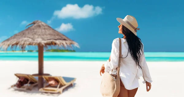 夏休み レジャーのコンセプト ビーチ沿いを歩くバッグ付きの白いシャツとわらの帽子の幸せな若い女性 — ストック写真