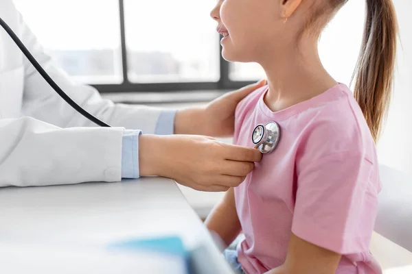 医疗保健和儿科概念 女医生或女儿科医生 带听诊器 以及在诊所接受体格检查的女童病人 — 图库照片