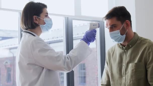 사람들의 병원에서 환자의 체온을 측정하는 적외선 온도계를 사용하여 마스크를 — 비디오