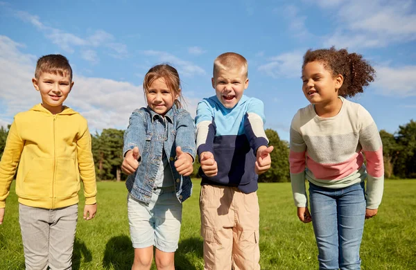子供時代 レジャー 人々の概念 公園で親指を示す幸せな子供たちの多民族グループ — ストック写真