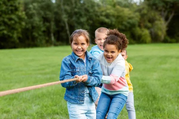 子供時代 レジャー 人々の概念 幸せな子供たちのグループは 綱引きゲームをプレイし 公園で実行しています — ストック写真