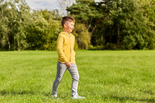 闲暇和人的概念 快乐的男孩在公园草坪上散步 — 图库照片