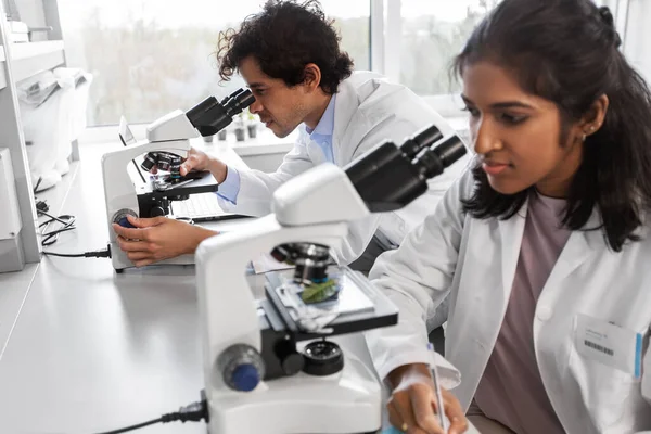 사람들의 현미경을 사용하여 실험실에서 일하는 과학자들로 이루어진 — 스톡 사진