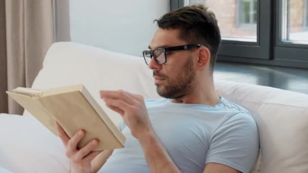 Conceito Pessoas Descanso Homem Óculos Livro Leitura Cama Casa — Vídeo de Stock