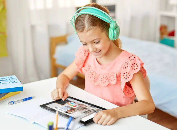 学校和远程学习概念 在家里带着平板电脑的耳机里快乐的学生女孩 — 图库照片
