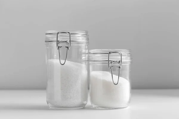 烹调和不健康的饮食习惯 关闭桌上的白糖和盐玻璃瓶 — 图库照片
