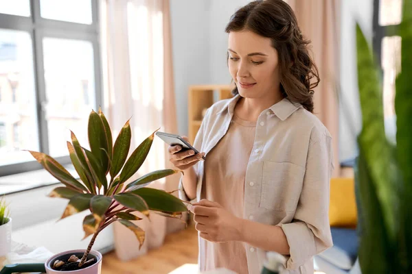 园艺和家务活的概念 快乐的女人 家里有智能手机和盆栽花 — 图库照片