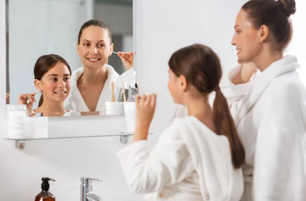 朝と人々のコンセプト 幸せな笑顔の母親と娘は綿棒で耳を掃除し バスルームで鏡を探しています — ストック写真