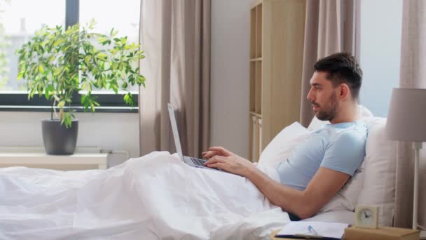 Menschen Technik Und Fernbedienungskonzept Mann Mit Laptop Heimischen Schlafzimmer Liegend — Stockvideo