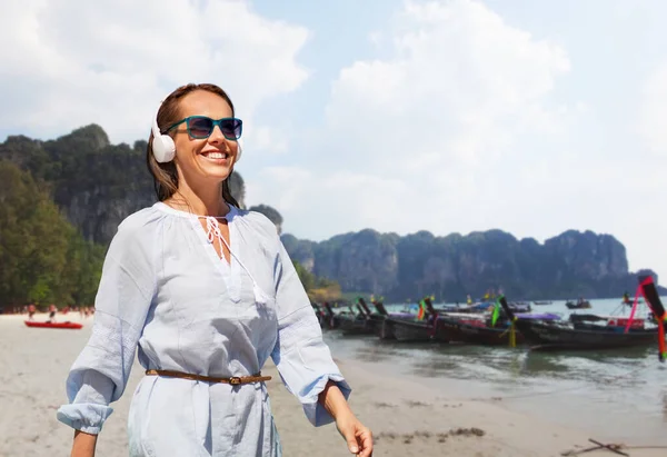 旅游和度假的概念 在法属波利尼西亚 带着耳机在热带海滩上散步的快乐微笑的女人 — 图库照片
