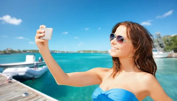 旅游和暑假 在法属波利尼西亚热带海滨背景的木制码头和小船上 一个带着智能手机的漂亮女人自拍 — 图库照片