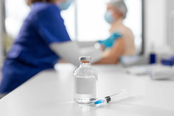 健康及防疫注射概念 医生或护士在医院为病人注射疫苗或药物时桌上的药瓶及注射器 — 图库照片