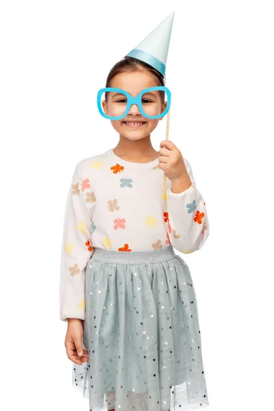 童年和人的概念 穿着礼服 戴着白色背景眼镜的派对帽的小女孩的肖像 — 图库照片