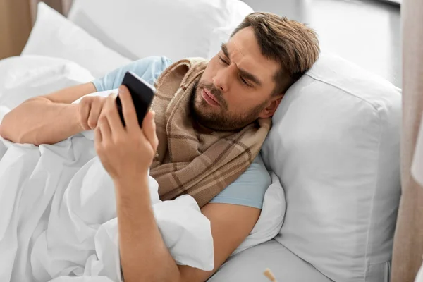 Gezondheid Ziekte Mensen Concept Zieke Man Met Smartphone Bed Thuis — Stockfoto