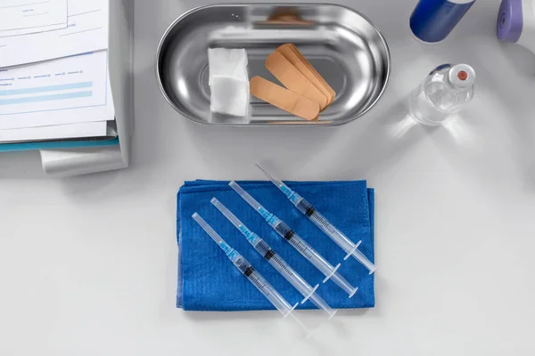 疫苗接种和保健概念 医院桌上蓝色擦拭一次性注射器和其他物品 — 图库照片