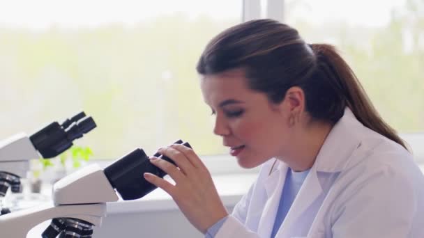 사람들의 현미경을 사용하여 실험실에서 일하는 과학자들로 이루어진 — 비디오