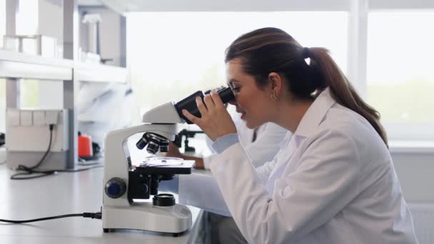 Vitenskapelig Forskning Arbeid Menneskers Konsept Kvinnelige Vitenskapsmenn Med Mikroskop Som – stockvideo
