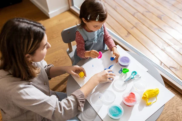 创造力和工艺概念 母亲和小女儿在家里玩粘土模型 — 图库照片