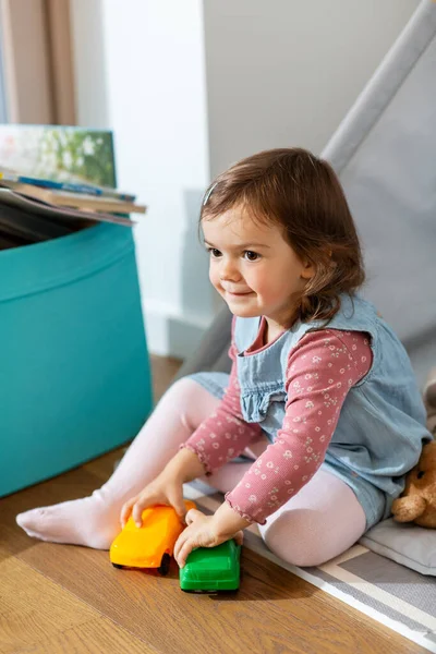 童年时期 嬉皮士和人的概念 小女孩在孩子们的帐篷里玩玩具汽车或在家里小憩 — 图库照片