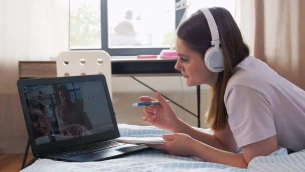网上教育和电子学习概念 戴耳机的少女 带着笔记本电脑 上化学课 在家里躺在床上给笔记本写信 — 图库视频影像