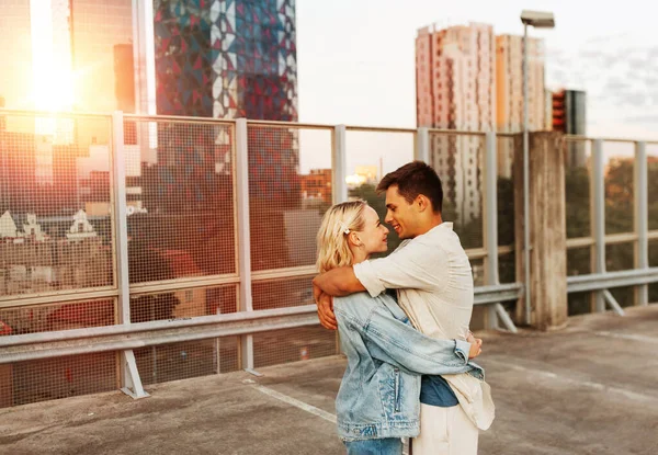 夏休み愛と人の概念 幸せな若いカップルが屋上都市駐車場で抱きつく — ストック写真