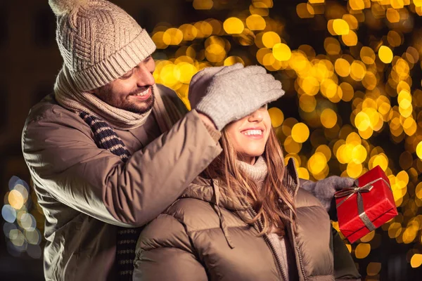 Zimowe Wakacje Koncepcja Ludzi Szczęśliwa Uśmiechnięta Para Prezentem Nad Lampkami — Zdjęcie stockowe
