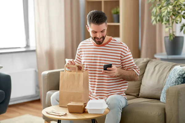 休闲和人的概念 男人使用智能手机外卖食品订单检查在家里 — 图库照片