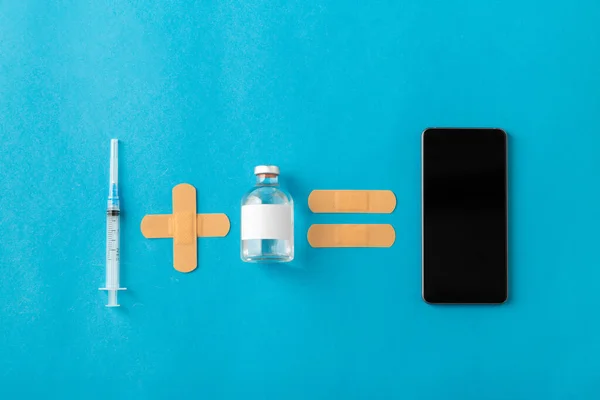 travel, vaccination and healthcare concept - disposable syringe, medicine, patches and smartphone on blue background