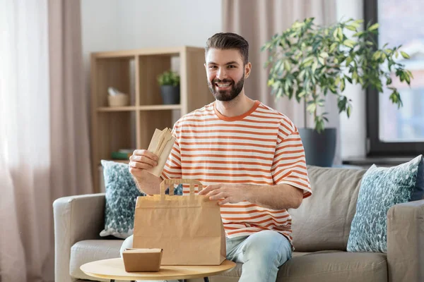 饮食和人的概念 微笑的男人在家里把外卖食品放进纸袋 — 图库照片
