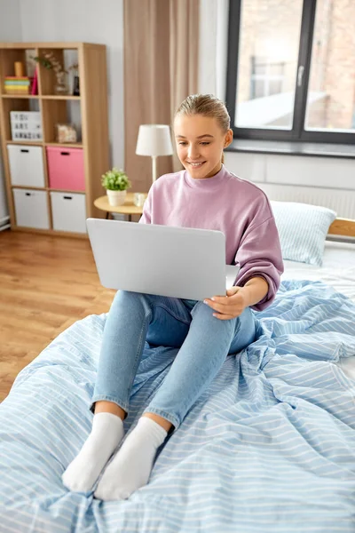 노트북 컴퓨터가 미소짓는 여학생 침대에 — 스톡 사진
