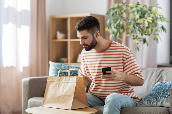 休闲和人的概念 男人使用智能手机外卖食品订单检查在家里 — 图库照片