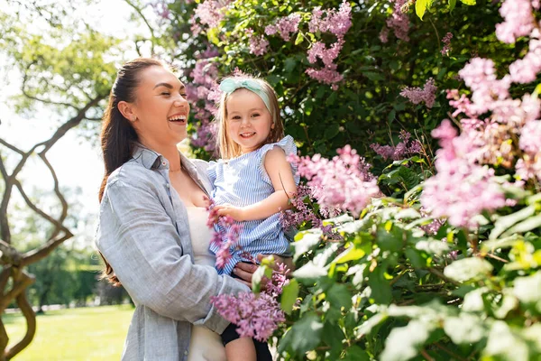 family, motherhood and people concept - happy mother with little daughter at summer park or garden