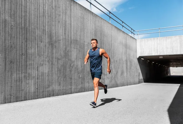 フィットネス スポーツ 健康的なライフスタイルのコンセプト トンネルを走っている若い男 — ストック写真