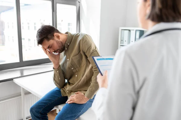 医疗保健和人的概念 有剪贴板的女医生和在医院有健康问题的悲伤男性患者 — 图库照片