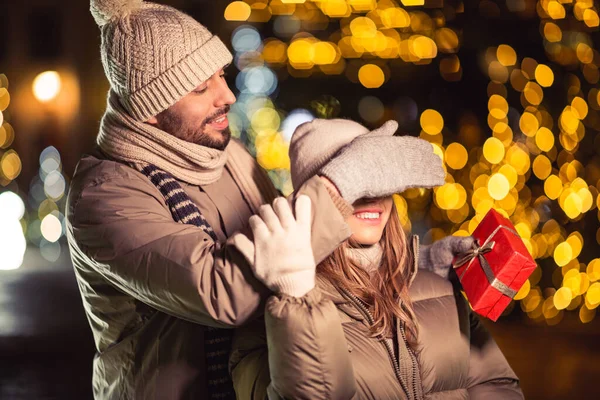 Zimowe Wakacje Koncepcja Ludzi Szczęśliwa Uśmiechnięta Para Prezentem Nad Lampkami — Zdjęcie stockowe